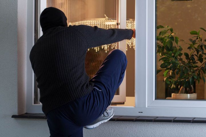 voleur qui tente de s'introduire dans une maison