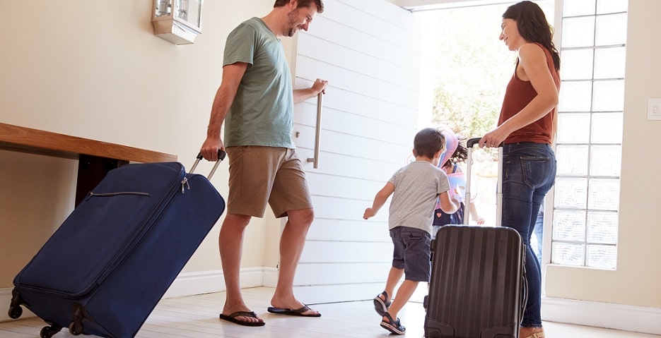 Famille sortant de sa maison pour partir en vacances