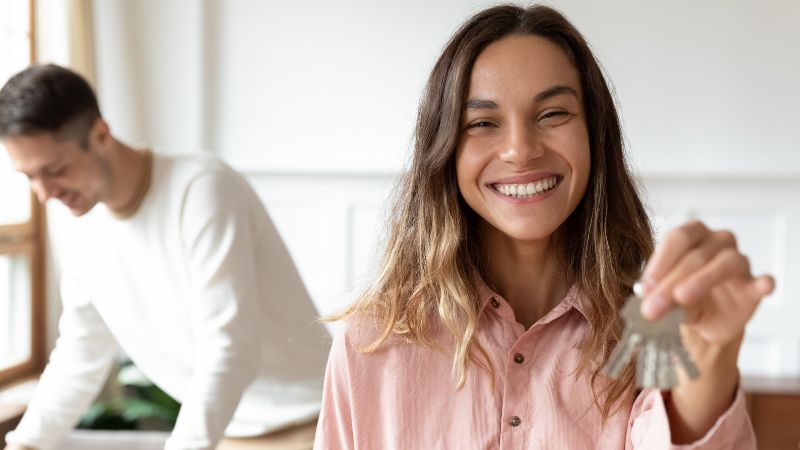 jeune femme souriante montrant ses clefs d appartement 