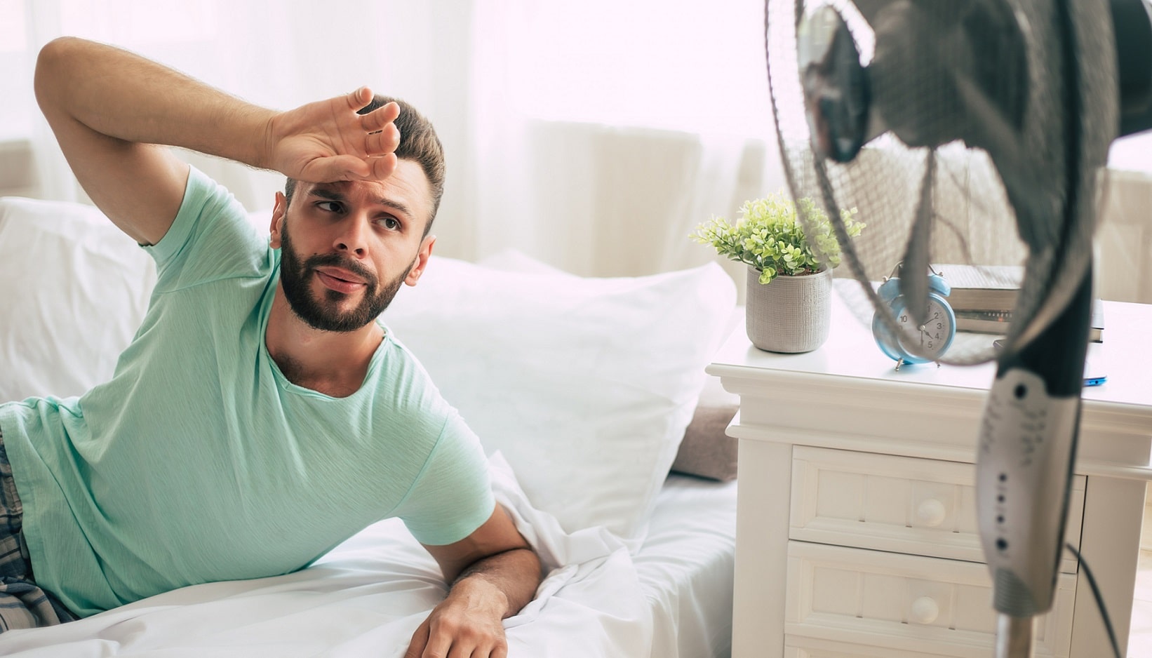 Jeune homme qui souffre de la canicule chez lui