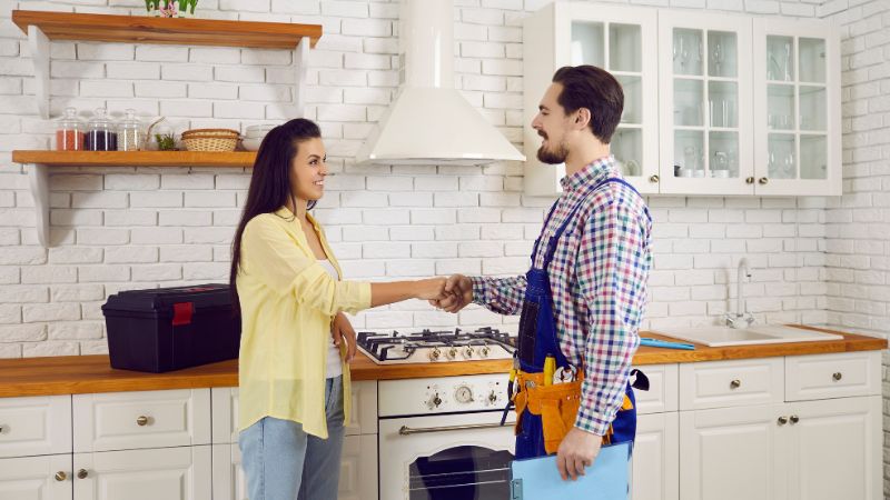 cliente souriante serrant la main a un plombier