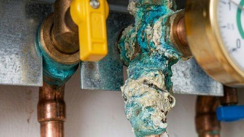 Raccord corrodé sur une chaudière qui goutte avec traces de rouille