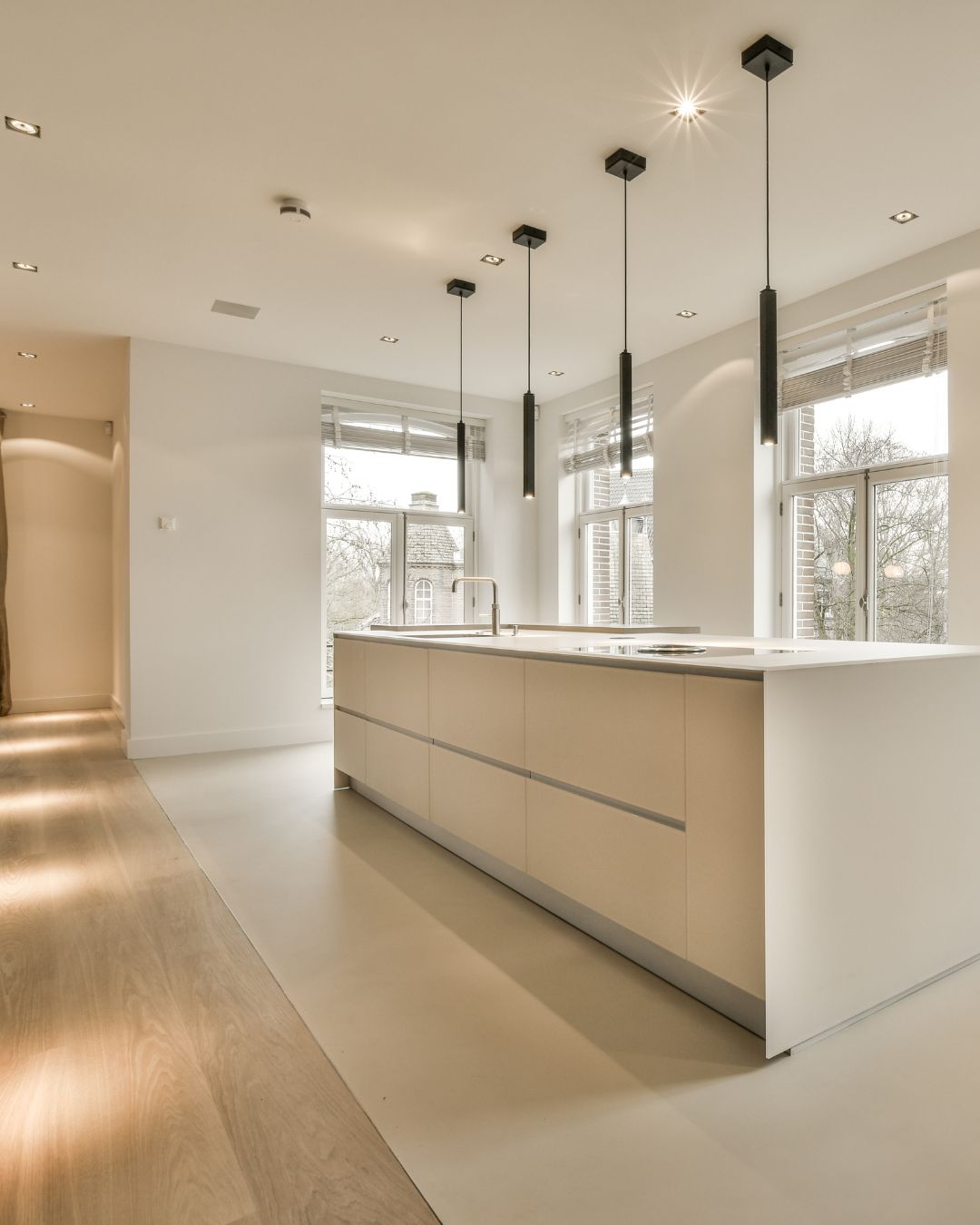 Cuisine ouverte avec îlot central blanc et mélange parquet et carrelage