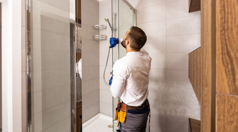 professionnel installant une paroi de douche coulissante vitrée