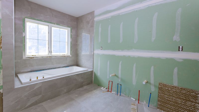 Chantier de rénovation d'une salle de bain avec conduites eau chaude et eau froide du futur meuble vasque apparentes