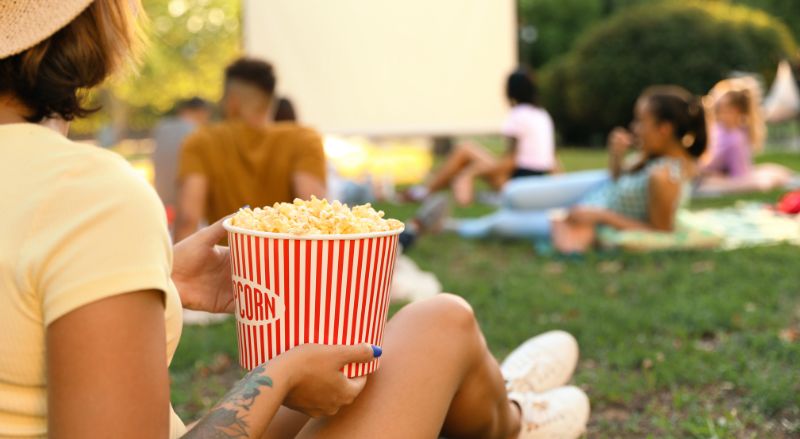 dégustation de pop-corn lors d'un cinéma en plein air dans un jardin