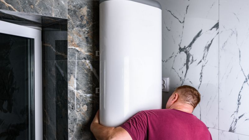 professionnel installant un chauffe-eau électrique plat dans une salle de bain