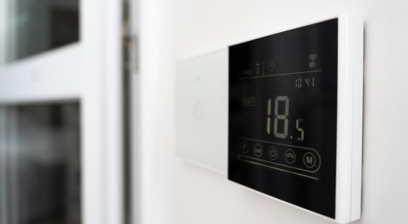 un dispositif de controle du chauffage par le sol ecran de thermostat sur le mur qui affiche une temperature de lair de 18 degres celsius