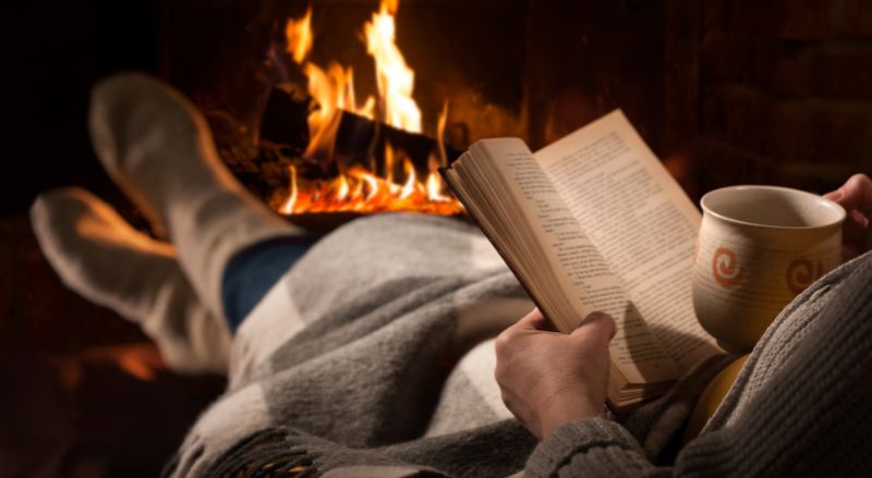 lecture et tasse de the devant un feu