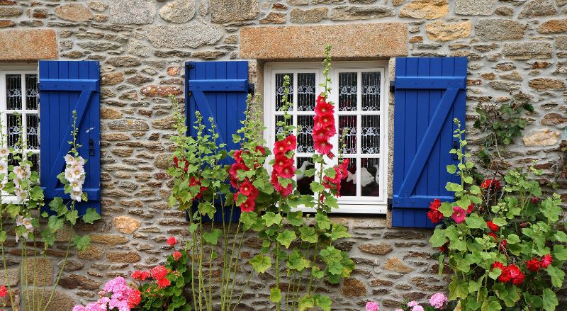 volets bleus sur une maison en pierre