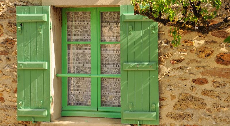 volets verts sur une maison en pierre