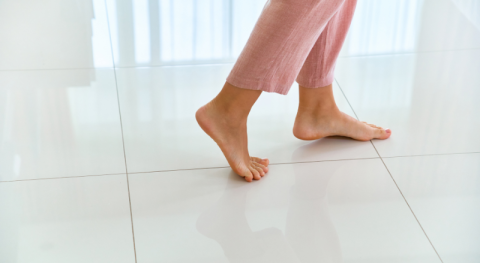 pieds nus feminins sur un sol carrelage chaud suggerant que le sol carrele a ete bien isole thermiquement