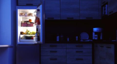 scene de cuisine nocturne avec un frigo ouvert eclairant vivement l intérieur soulignant l l inconvenient quand ce frigo ne s allume plus