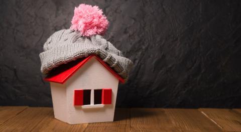 concept du systeme de plafond chauffant et temps hivernal avec maquette dune maison portant un bonnet en tricot de laine