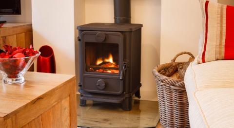 poele a bois en fonte noir installe dans une cheminee a lhabillage blanc dans un interieur moderne