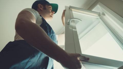 professionnel reparant et ajustant une fenetre en pvc